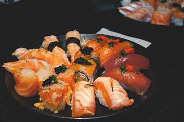 tuna, salmon, shrimp and white fish sushi on black background 
