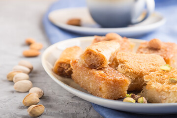 traditional arabic sweets and a cup of coffee on a gray concrete background. side view, selective focus.