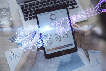 Double exposure of man's hand holding and using a digital device and data theme hologram drawing....