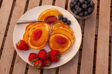 homemade cupcakes with fresh strawberries, blueberries and strawberry jam on a wooden table