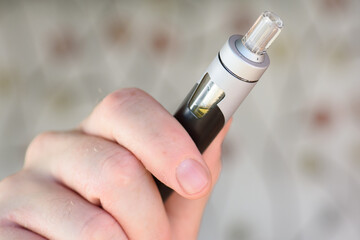 A man holding a vaping device also known as an electronic cigarette.