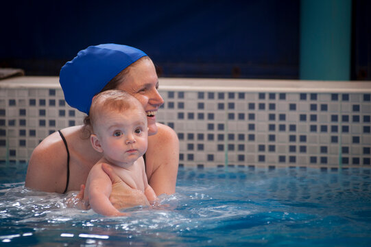 Mother and 9 months old premature son photographed during a swimming lesson in a pool.