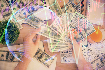 Multi exposure of financial graph drawing hologram and USA dollars bills and man hands. Analysis concept.