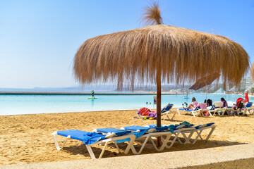 Lounge chairs on the sand at the beach during summer for vacation.