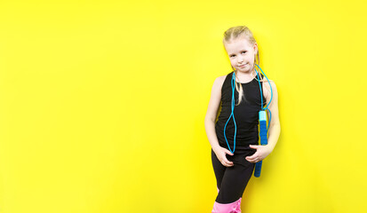Fototapeta na wymiar Theme sport and health. Beautiful caucasian child girl with pigtails posing yellow background with smile. little athlete holds sport rope in hands. Banner advertising, space for text copy space blank