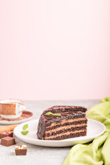 Homemade chocolate cake with milk cream and a cup of coffee on a gray and pink background. side view, selective focus, copy space.