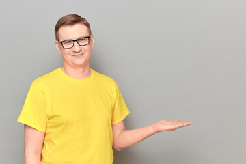 Portrait of happy man showing copy space over open palm and smiling