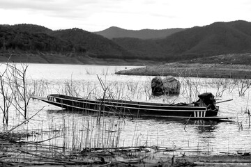 A fishing boat is standing still at the dam with a beautiful view