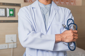 Doctor standing with folder at hospital. Attractive doctor in front of at hospital background. Doctor working at hospital and smiling at camera.