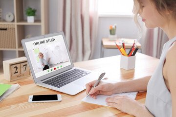 Young woman using laptop for online studying at home, closeup