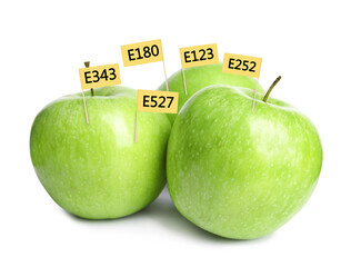 Fresh apples with E numbers on white background. Harmful food additives