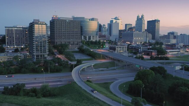 Aerial flying over downtown Kansas City and freeway traffic at sunset. Missouri, USA
