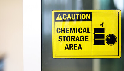 Black-yellow Chemical storage area Hazard Sign and symbol on the glass door, Caution for warning dangerous space in laboratory room. selective focus on tag, blurred background Safety first concept.