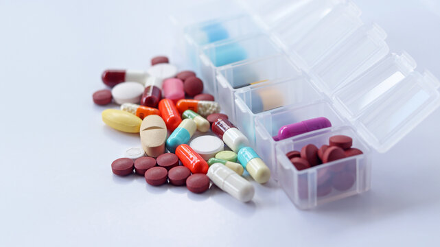 Pill box daily take a medicine, with colorful of pills, tablets, and capsules. Drugs use for treatment and cure the disease. Medication in medical clinic isolated in white background, has copy space.