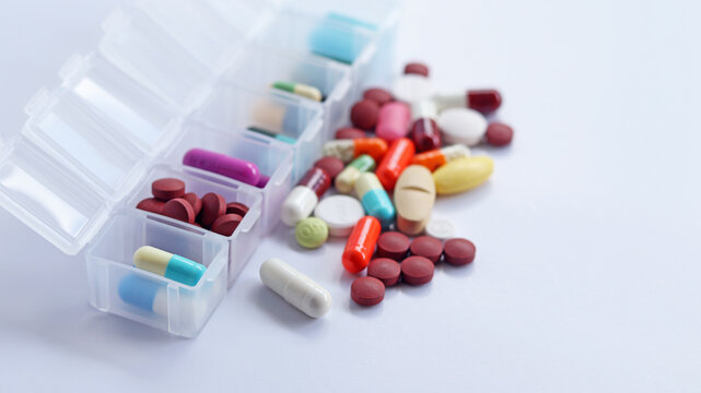 Pill box daily take a medicine, with colorful of pills, tablets, and capsules. Drugs use for treatment and cure the disease. Medication in medical clinic isolated in white background, has copy space.