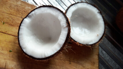 Fototapeta na wymiar Two coconut half on the chopping plank.Fresh coconut half ready to grind.