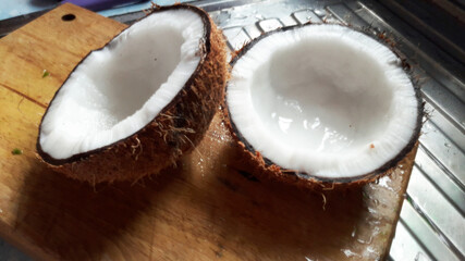 Two coconut half on the chopping plank.Fresh coconut half ready to grind.