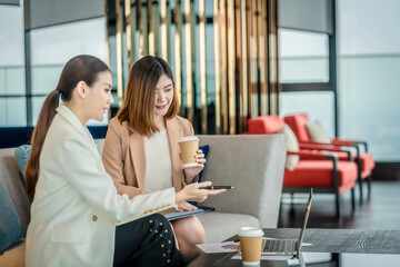 Team work process. Two women with laptop in open space office. Business concept., two women is meeting for business matching. ,Two young beautiful asian business woman in the conversation.