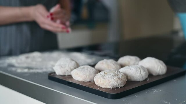 Close-up of a tasty cutlets, a female cook cooks meatballs, dipping cutlets of minced meat in flour and spreading it on a baking tray.