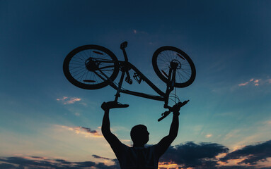  Young guy holds the bike on outstretched arms