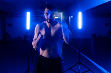 Fototapeta na wymiar boxer in motion shooting blue light