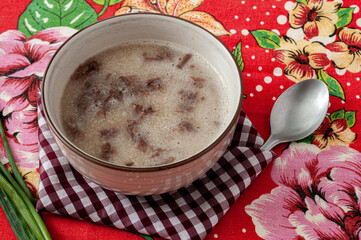 tasty cassava soup with meat on colorful table