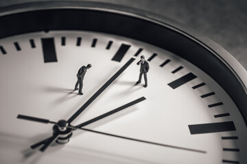 Two businessman standing in the middle of clock face. Business concept