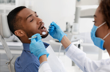 Patient with open mouth having dental treatment