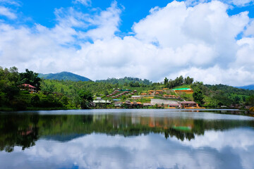 Fototapeta na wymiar An Asian hill village with a lake landscape and blue sky background
