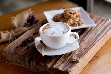 Cup of coffee with cookies in cafe.Side view coffee with some cookies on the wooden table.
