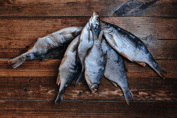 Salty dry river fish on a dark wooden background. Dry fish in the market. Street food.