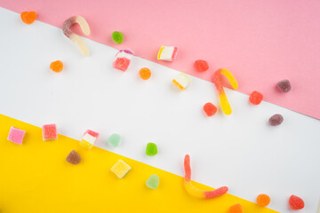 Abstract arrangement of candies and sweets on multi colored background