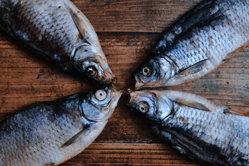 Salty dry river fish on a dark wooden background. Dry fish in the market. Street food.
