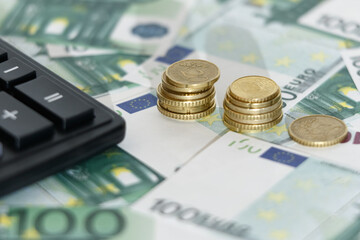 Euro banknotes with a calculator and coins. Business concept