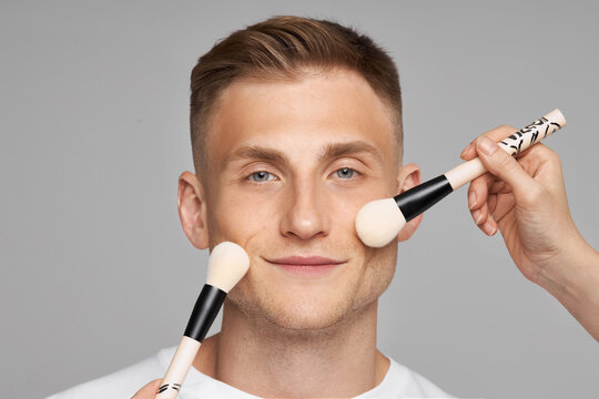 Cosmetics for men's makeup. Face cosmetics. Women's hands with a brush Touch Man's Face with the base