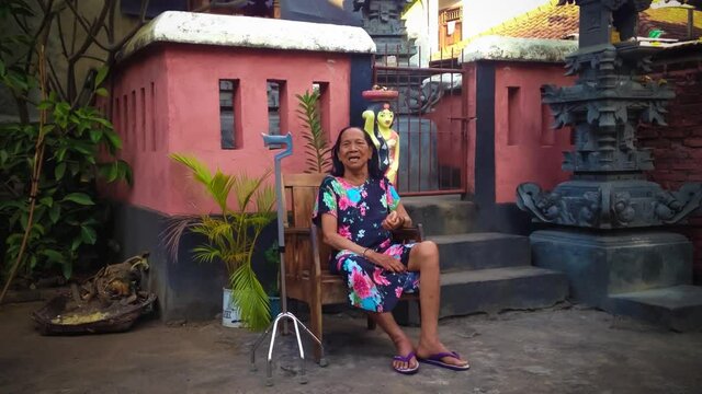 A Grandmother In The Hallucinations Sit Crying Like A Child Wanting Something In Her Imagination In Front Of Balinese House Shrines