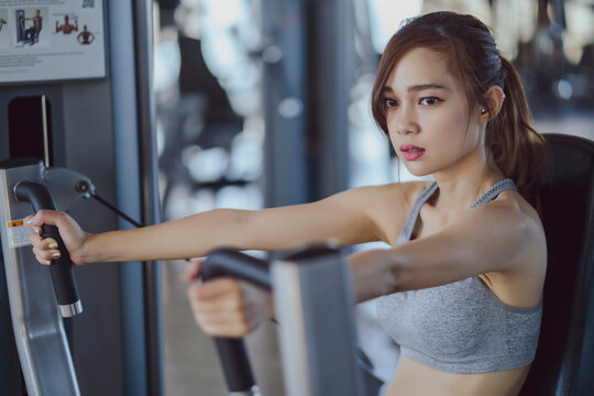 fitness new normal, Woman at the gym on a sports simulator., Fit beautiful young woman exercise workout on machine in gym. Glad smiling girl is enjoy with her training process. Concept of fitness, Hea