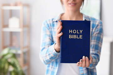 Young woman with Bible at home