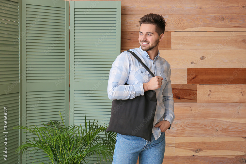 Wall mural Young man with eco bag at home