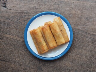 Top view deep fried spring rolls with wooden background