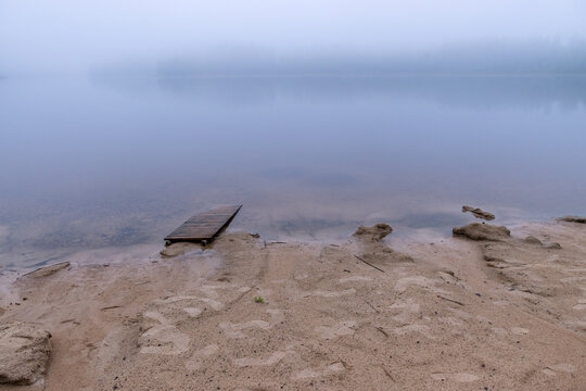 Sandy Beach After Heavy Rain, White Fog On The Lake, Fuzzy Contours