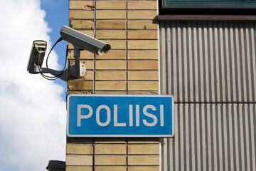 Finnish police sign with surveillance cameras on building wall, Finland Europe