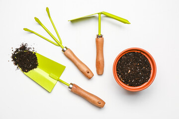 Set of gardening supplies with soil on white background