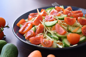 Cucumbers, tomatoes, cabbage and carrot salad.  Vegetable salad.  Healthy and dietary food concept.  Selective focus.