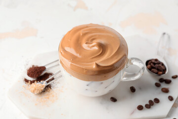 Glass cup of tasty dalgona coffee on white background
