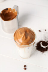 Glass of tasty dalgona coffee on table