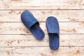 Pair of soft slippers on wooden background
