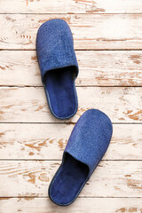 Pair of soft slippers on wooden background