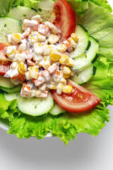 Fresh lettuce salad with tomatoes, red onion, corn, carrots, cucumber