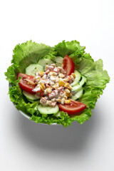 Fresh lettuce salad with tomatoes, red onion, corn, carrots, cucumber